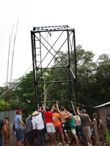 Volunteers pushing up the water tower for the Gigante Community Health Center. Photo: Angela R. Kirwin