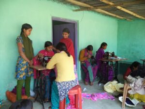 More students at the KIRF Sewing Center. Some watching some sewing.