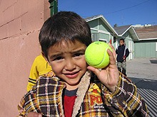 A young boy from Tijuana holding a tennis ball