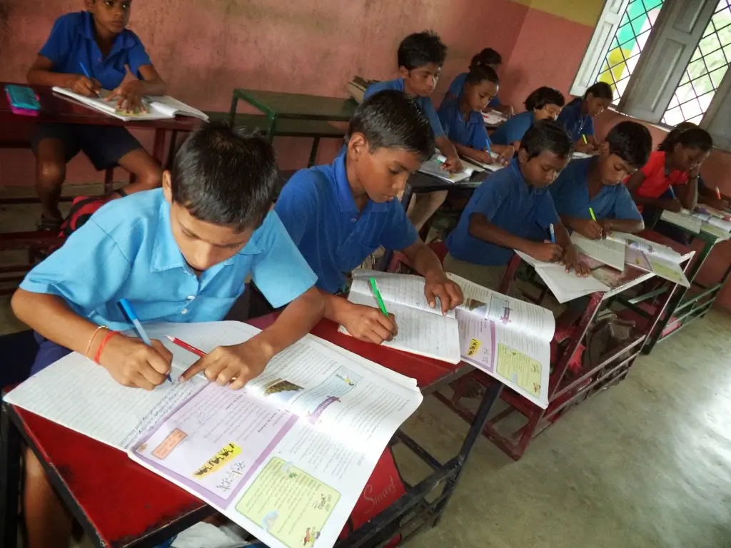 Children writing at classroom desks